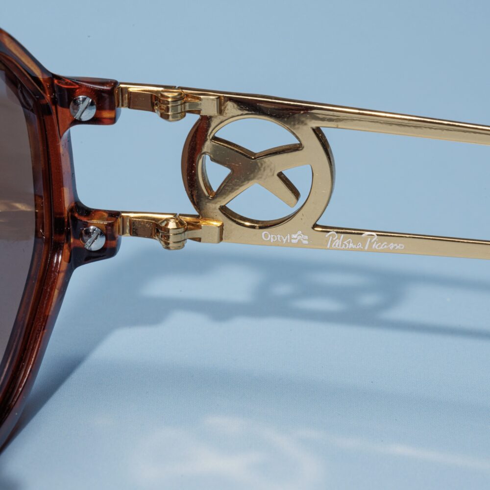 Lunettes de soleil vintage des années 80 de la marque Paloma Picasso. Monture en acier doré et en acétate brun fabriquée main en Allemagne d'un savoir-faire lunetier authentique, avec des verres bruns fantastiques. Les lunettes Paloma Picasso sont toutes fabriquées à la main, avec des matériaux soigneusement choisis.
