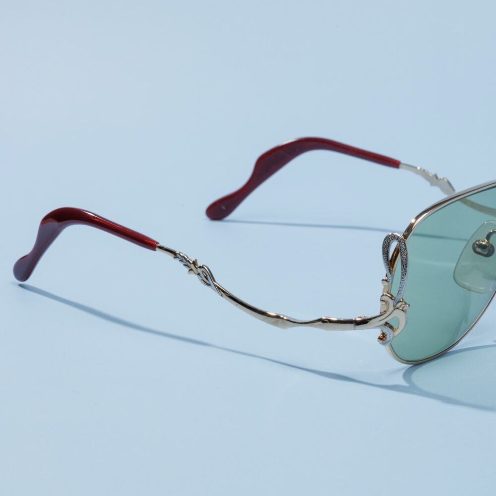 Lunettes de soleil pilote vintage des années 80 de la marque emblématique Colani. Monture en acier argenté et doré fabriquée main en France d'un savoir-faire lunetier authentique, avec des verres verts fantastiques.