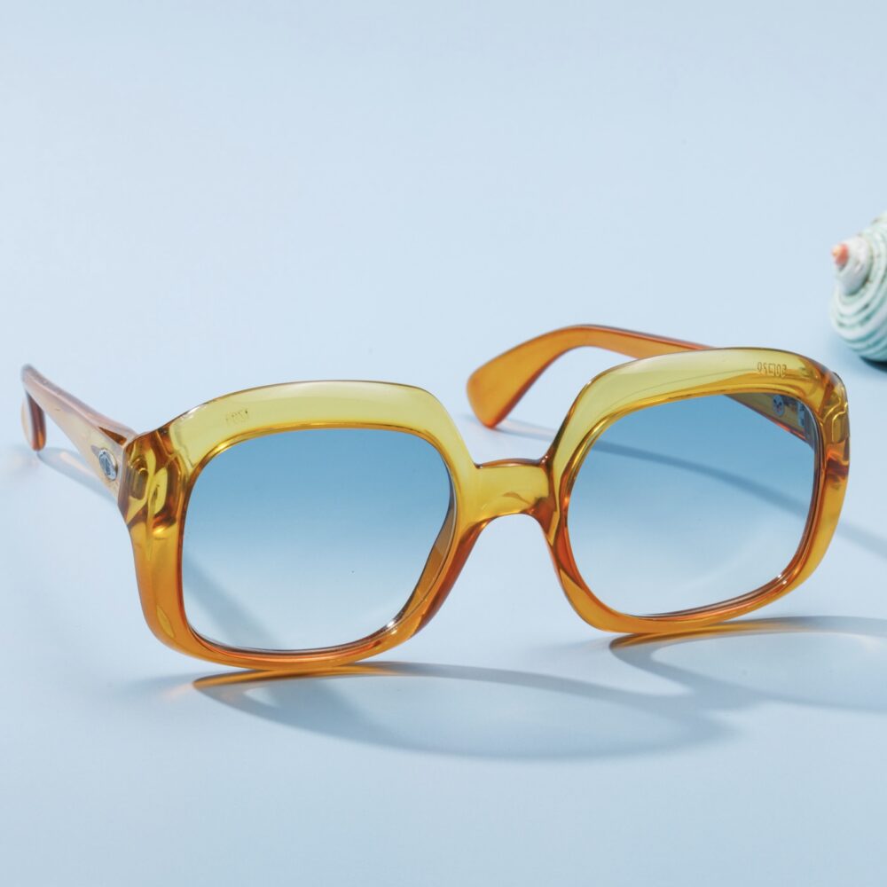 Lunettes de soleil vintage des années 60 de la prestigieuse maison de couture Christian Dior. Monture en acétate dégradé jaune et orange fabriquée main en France d'un savoir-faire lunetier authentique, avec des verres bleus fantastiques.