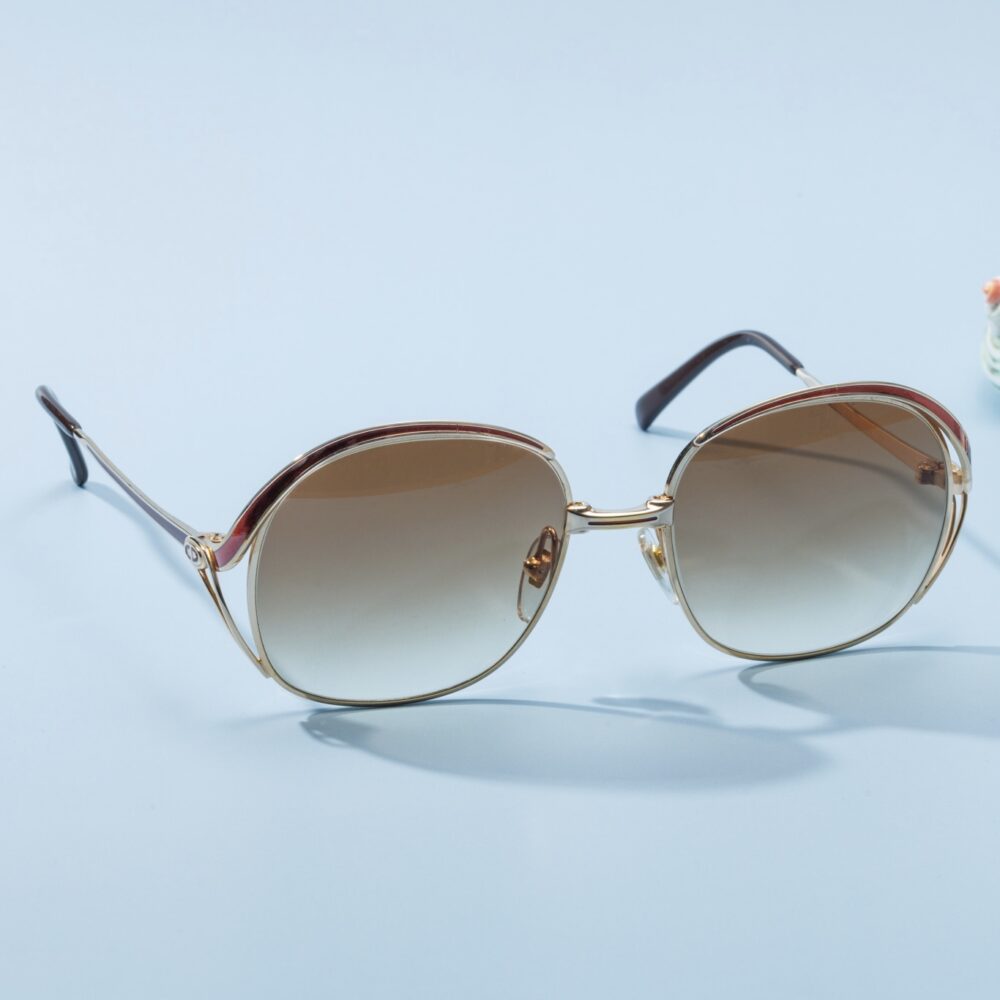 Lunettes de soleil vintage des années 60 de la prestigieuse maison de couture Christian Dior. Monture en acier doré et bordeaux fabriquée main en France d'un savoir-faire lunetier authentique, avec des verres verts fantastiques. Les lunettes Dior sont tous fabriqués à la main, avec des matériaux soigneusement choisis.