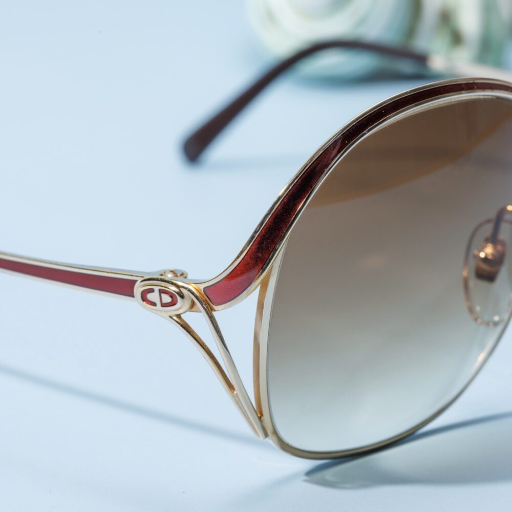 Lunettes de soleil vintage des années 60 de la prestigieuse maison de couture Christian Dior. Monture en acier doré et bordeaux fabriquée main en France d'un savoir-faire lunetier authentique, avec des verres verts fantastiques. Les lunettes Dior sont tous fabriqués à la main, avec des matériaux soigneusement choisis.